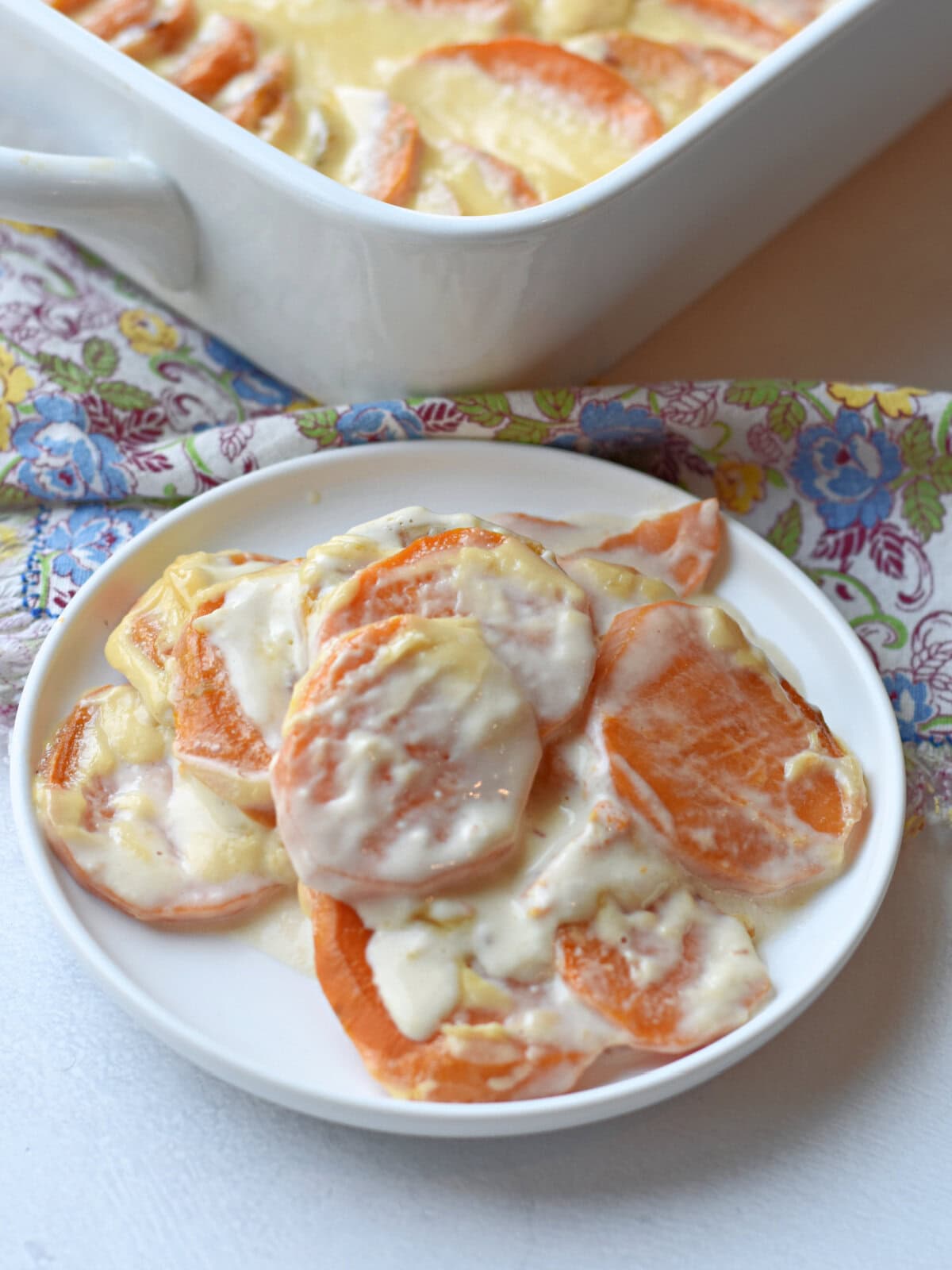scalloped-sweet-potatoes-recipe Scalloped Sweet Potatoes on a white serving dish.