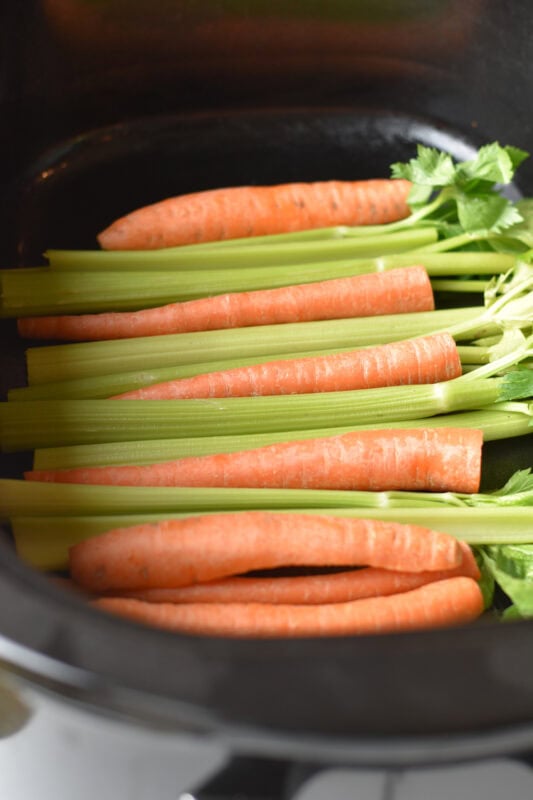 Whole carrots and ribs of celery side-by-side.