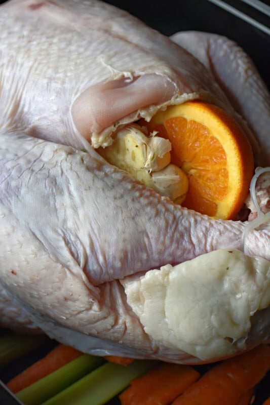 Aromatics stuffed into the cavity of a fresh turkey, ready to be cooked.