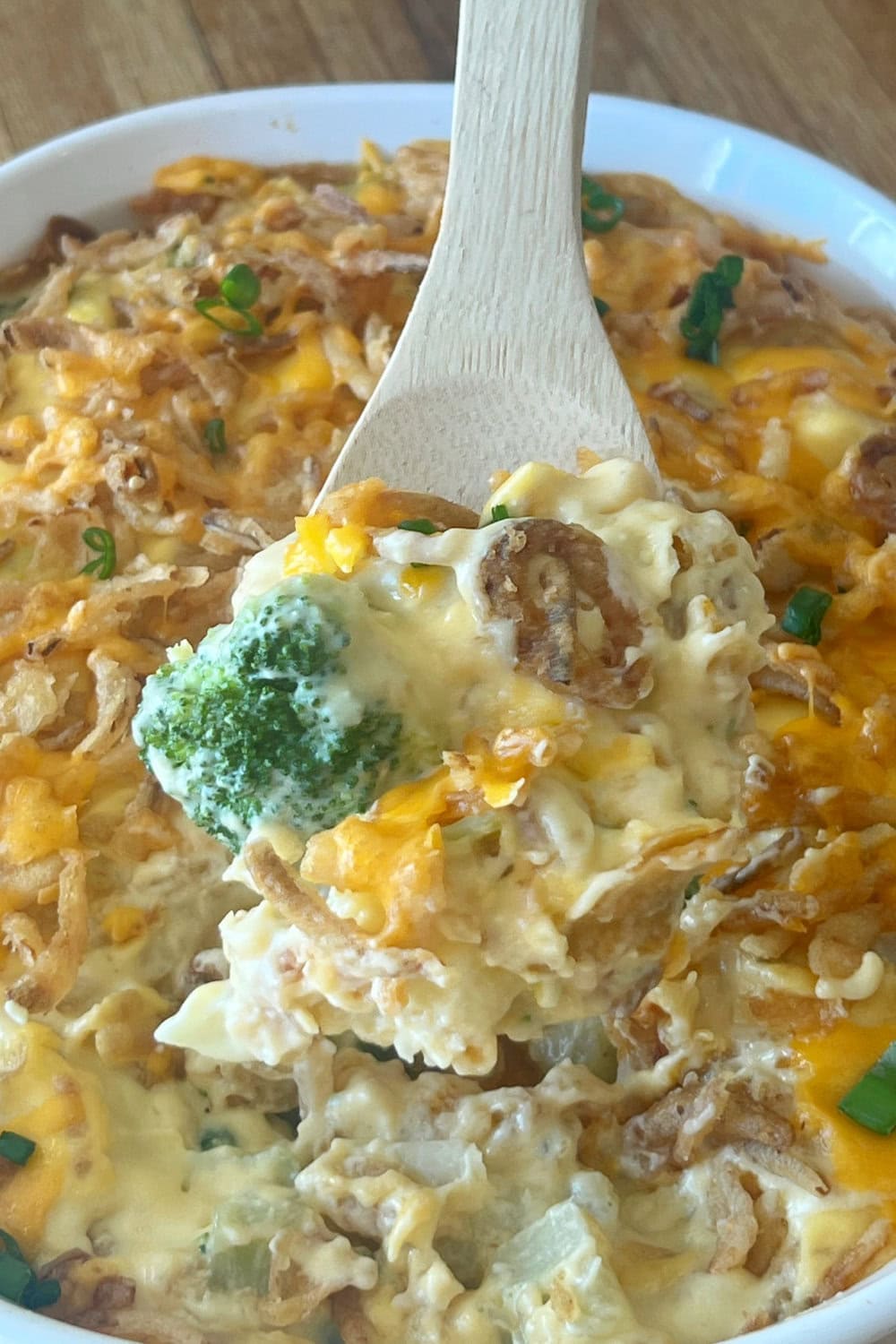 A heaping spoonful of Broccoli Cauliflower Casserole on a serving spoon. 