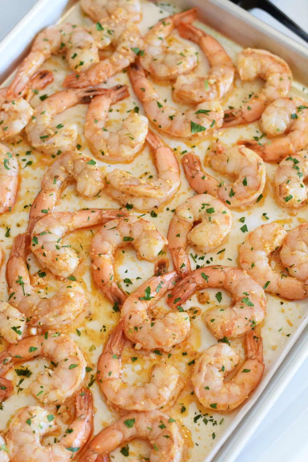 Shrimp cooked on a sheet pan in the oven with a lemon parmesan sauce. 