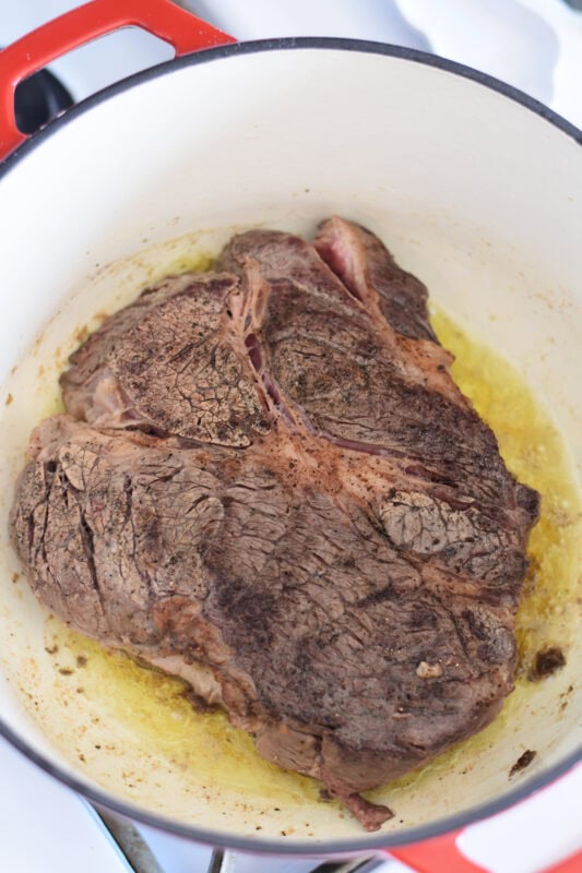 Chuck roast in a dutch oven with olive oil. 