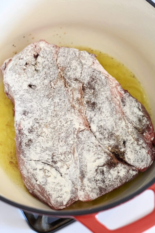 Searing a floured meat in a dutch oven. 