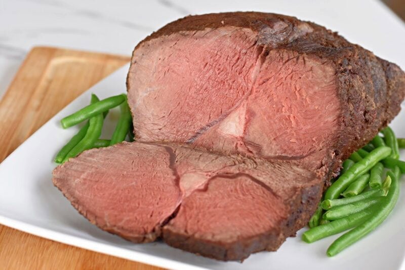 sirloin-tip-roast-beef-slice Perfectly medium-rare Sirloin Tip Roast surrounded by fresh green beans.