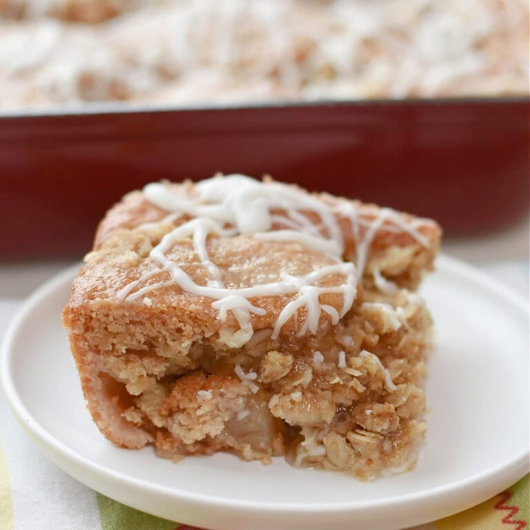 Applesauce crumb cake slice on a white plate.