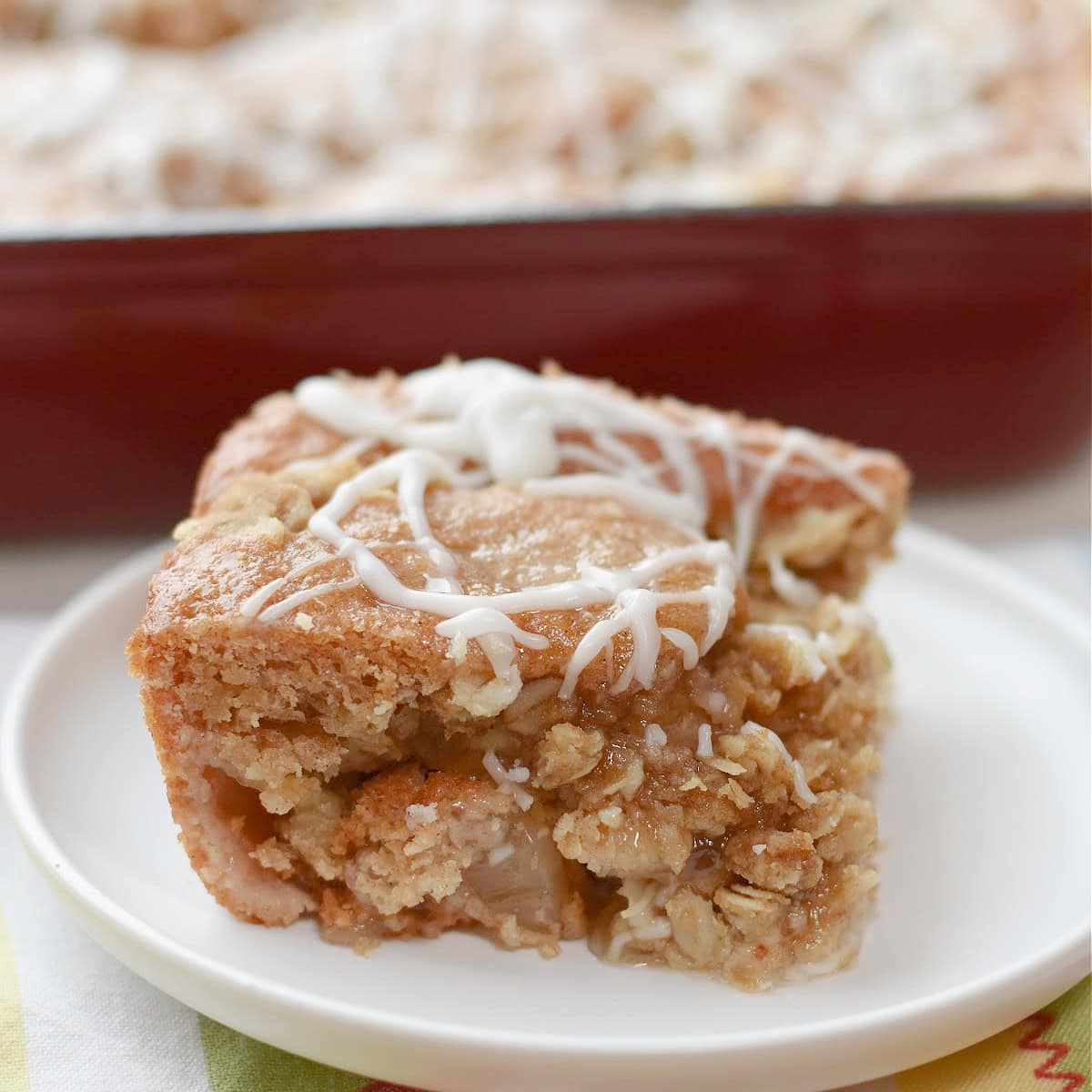 Applesauce crumb cake slice on a white plate.