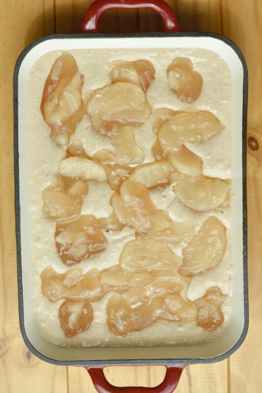 batter-apple-pie-filling Batter with with apple pie filling in a baking pan.