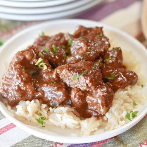 Chunks of stew meat served with dark brown gravy.