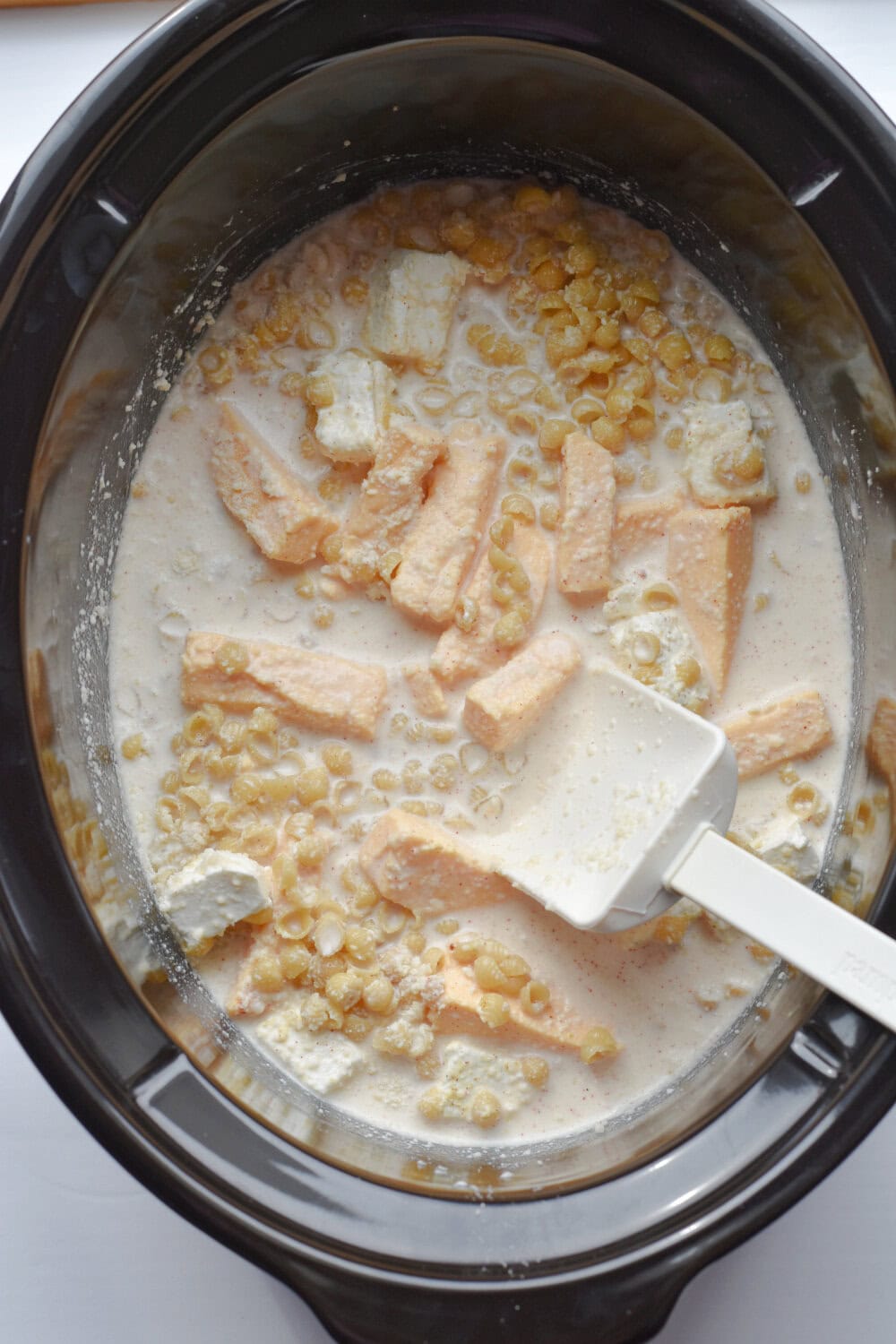 uncooked-pasta-crock-pot Uncooked cheeses mixed with uncooked pasta in a crock pot.