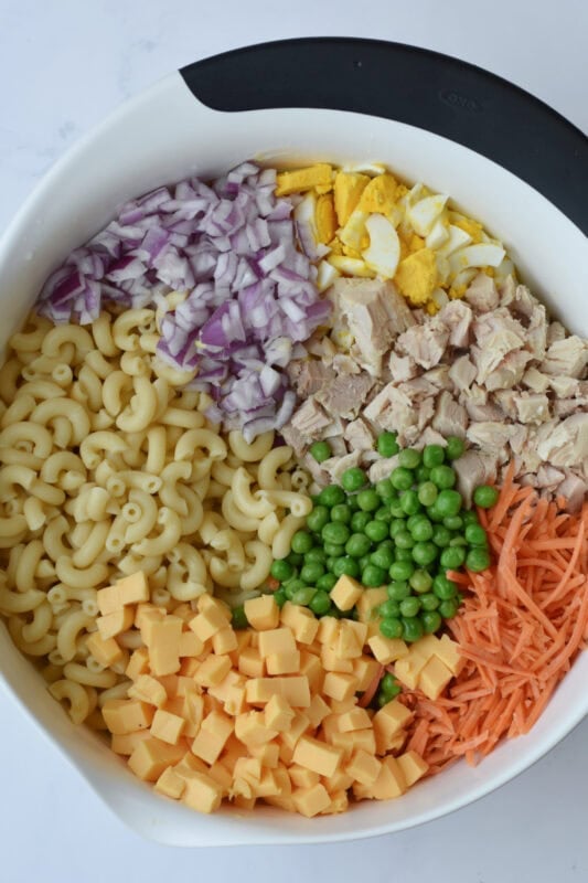 chicken-pasta-salad-unmixed Chopped ingredients in a bowl on top of the dressing.