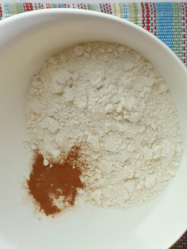 Flour, baking soda, salt, cinnamon, and nutmeg in a bowl. 