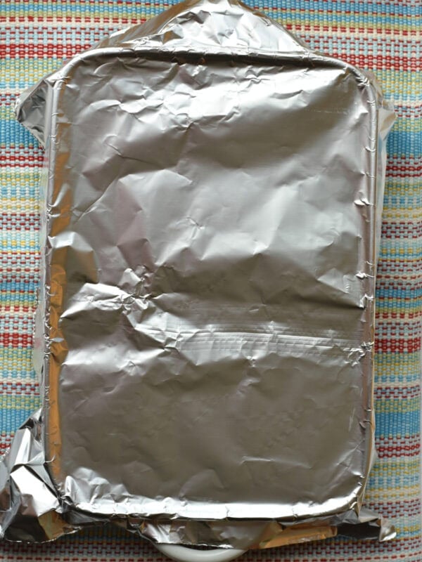Covering sheet pan cake with foil to make it moist. 