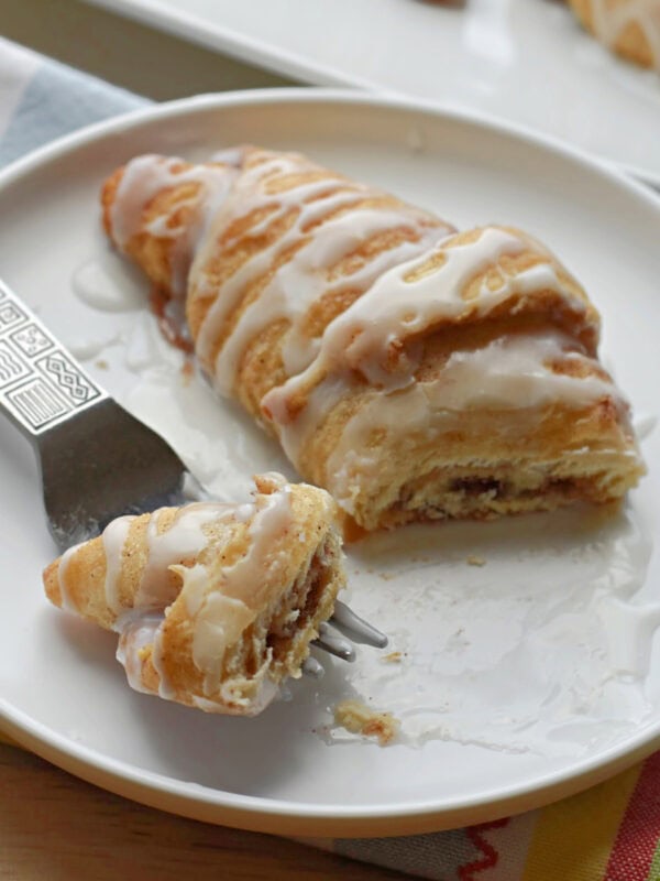 Crescent Roll Cinnamon Roll on a white plat with a fork. 
