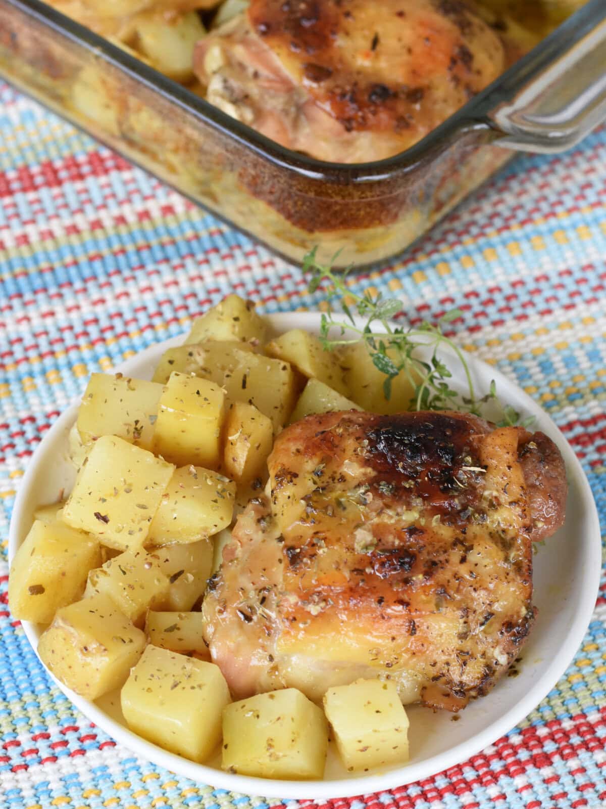 chicken-thighs-potatoes-serving Chicken Thighs and Potatoes baked in one pan served on a white plate.