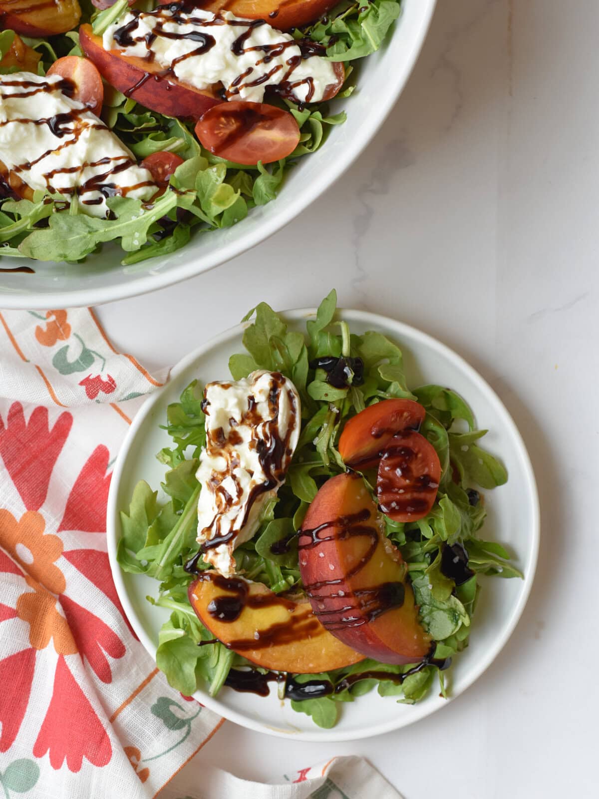Peach-Burrata-Salad-Plated Burrata salad with peaches on a white serving plate.