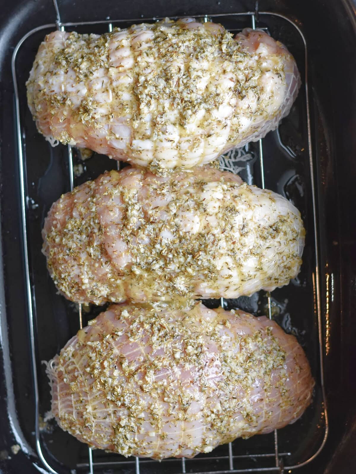 Roasts in a roaster oven on a rack. 