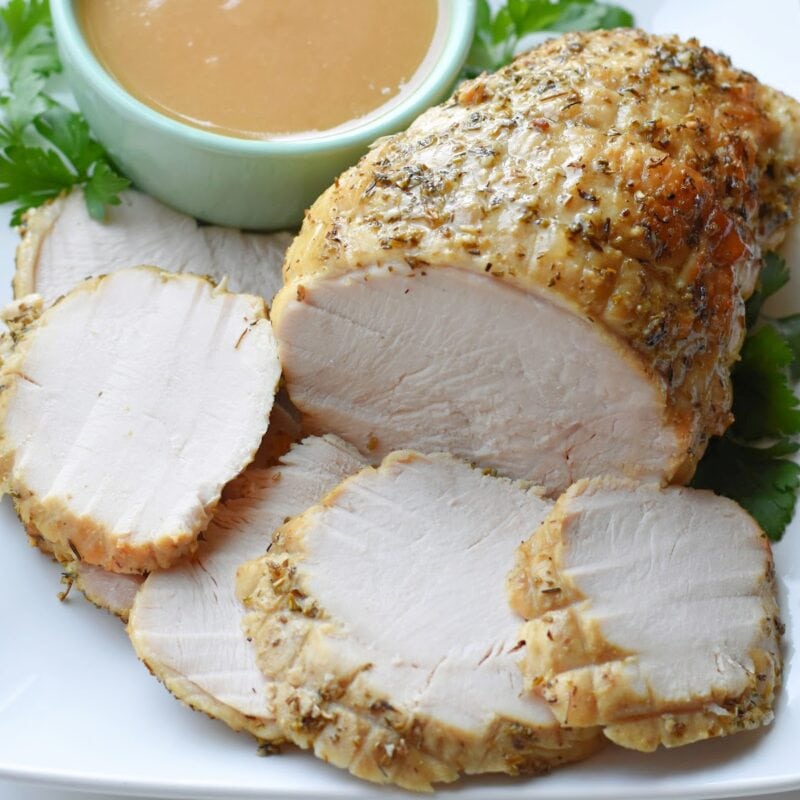 Boneless turkey breast made in the electric roaster oven on a white plate with gravy.