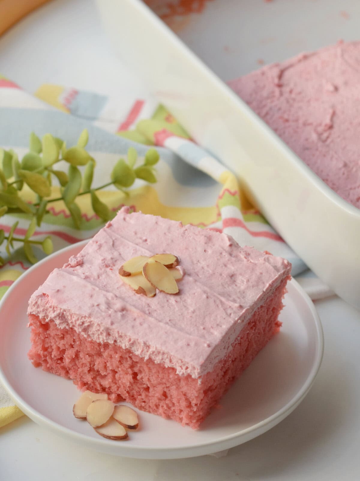 A Cherry Almond Cake made in a 9X13 cake pan with a piece cut out. 