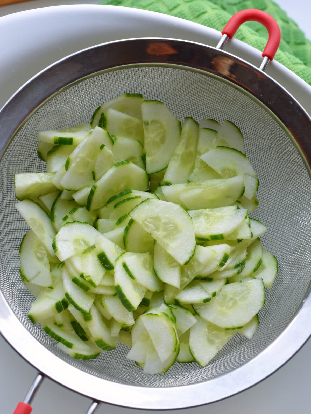 Sliced english cucumbers in a strainer. 