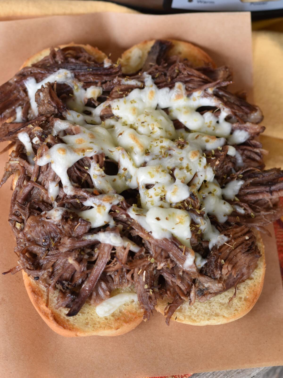 Chuck roast on a sub bun with shredded cheese. 