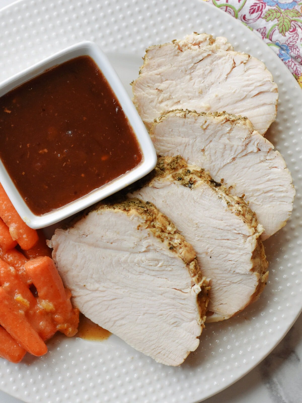 Sliced turkey breast made in the slow cooker with cranberry sauce and carrots. 