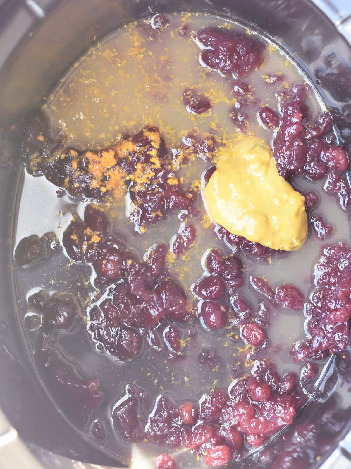 Cranberry sauce, orange zest and butter in a crock pot. 