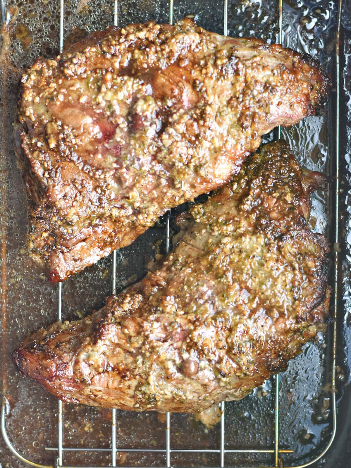 Cooked beef resting in a roasting pan. 