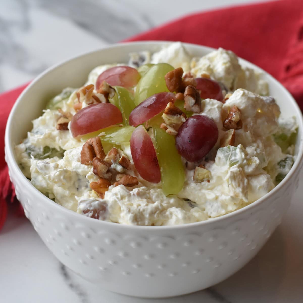 Christmas Fruit Salad with fluffy marshmallows, celery, grapes, cream cheese and pecans.