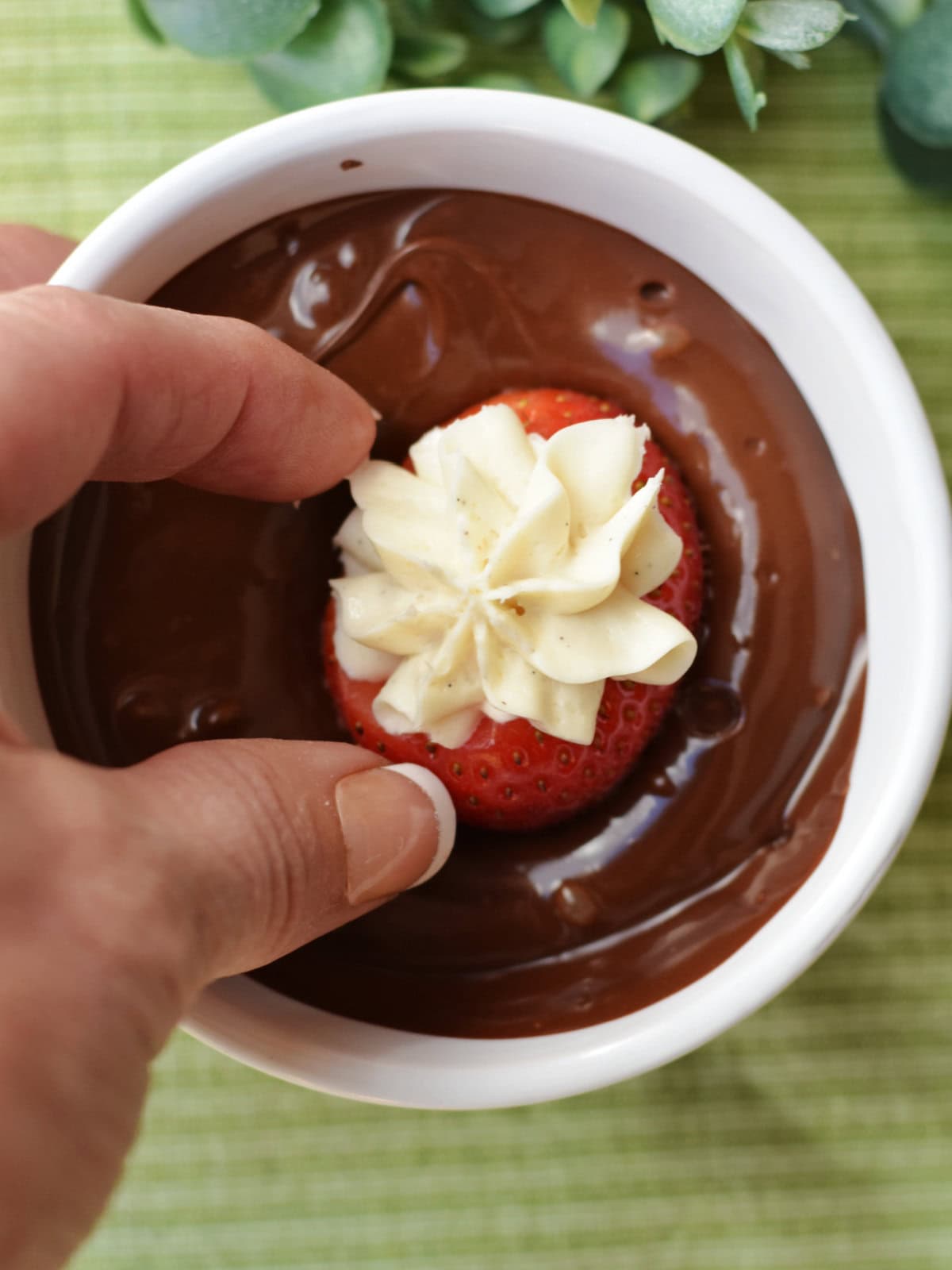 Dipping the filled strawberries in chocolate. 
