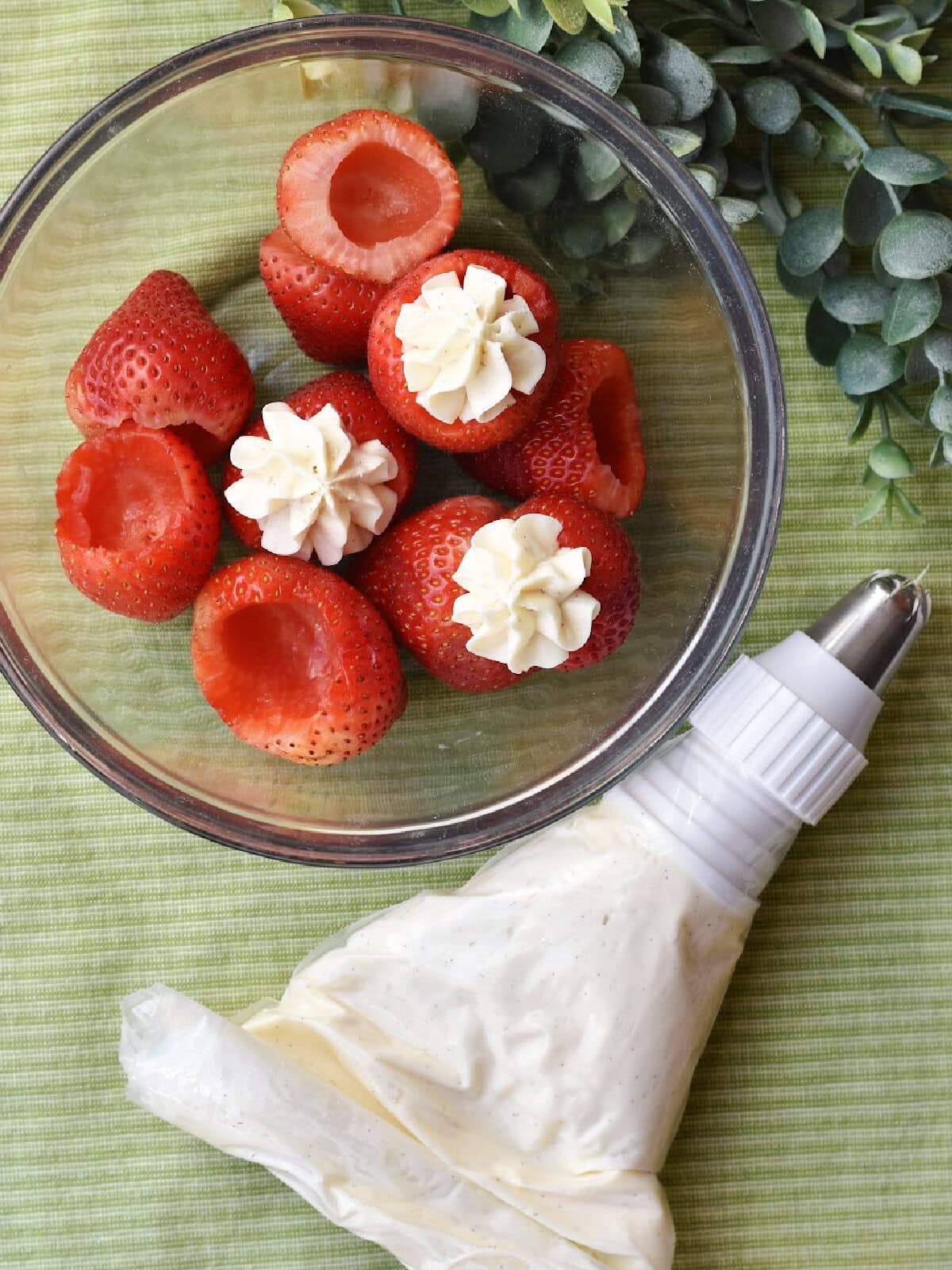 Filling the strawberries with the cream in a bowl. 