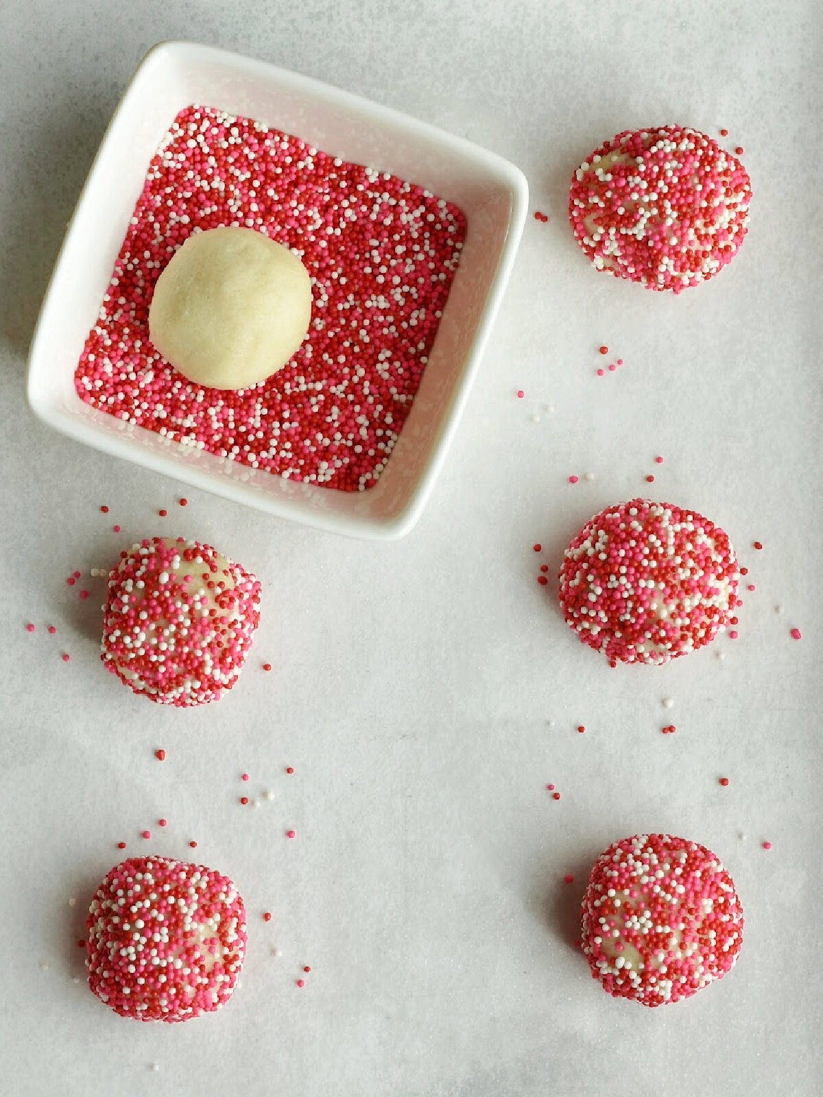 Uncooked dough in balls with sprinkles. 