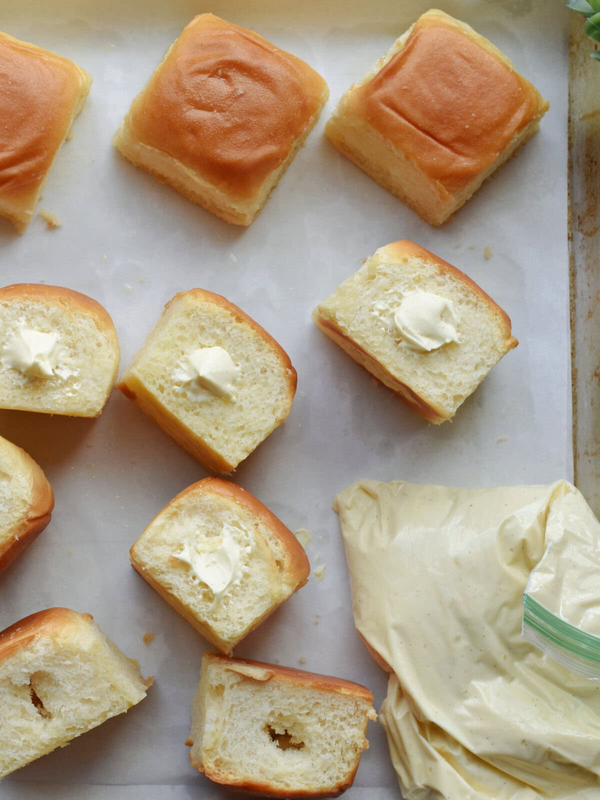 Filled rolls with cream and a plastic bag filled with cream for piping into the rolls. 