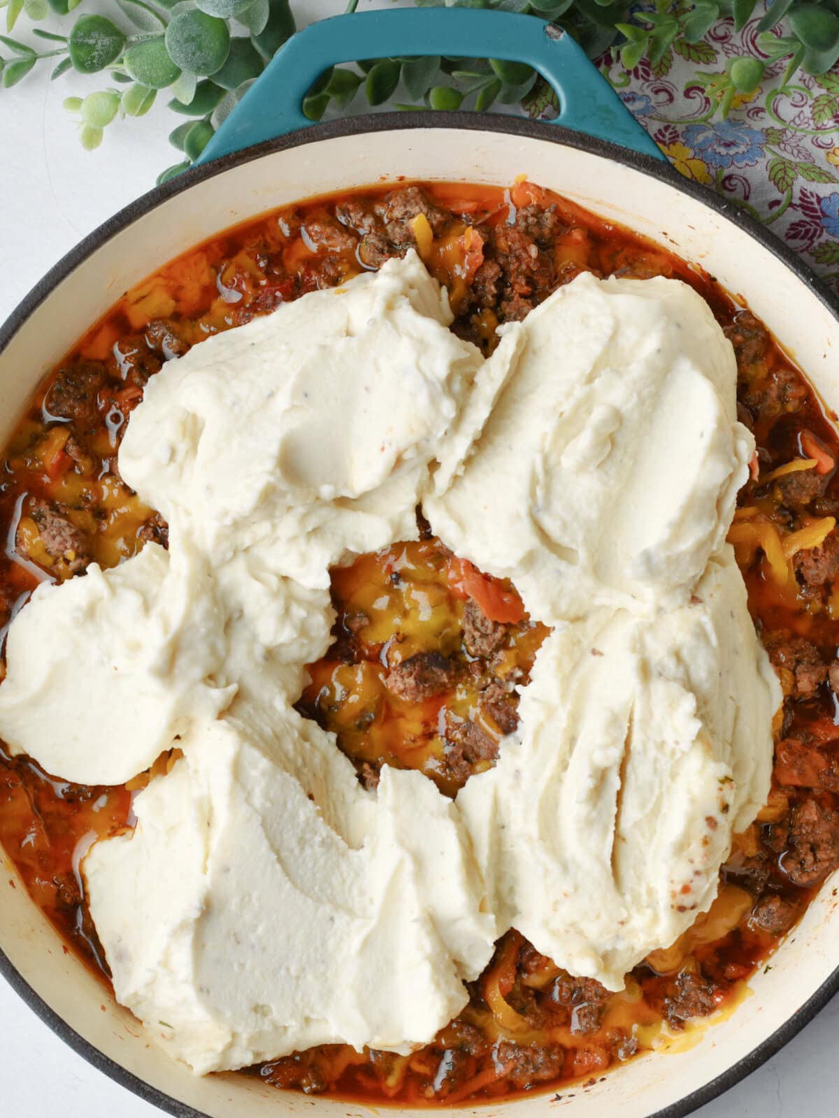 Mashed potatoes on the beef mixture. 
