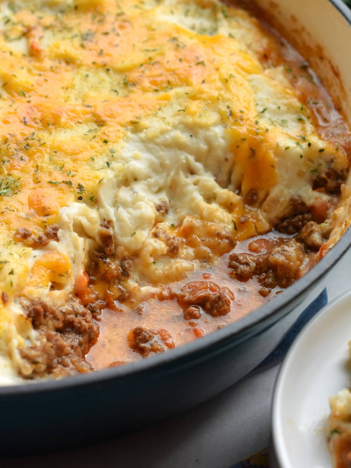 Cooked Shepard's Pie with a serving missing in a skillet. 