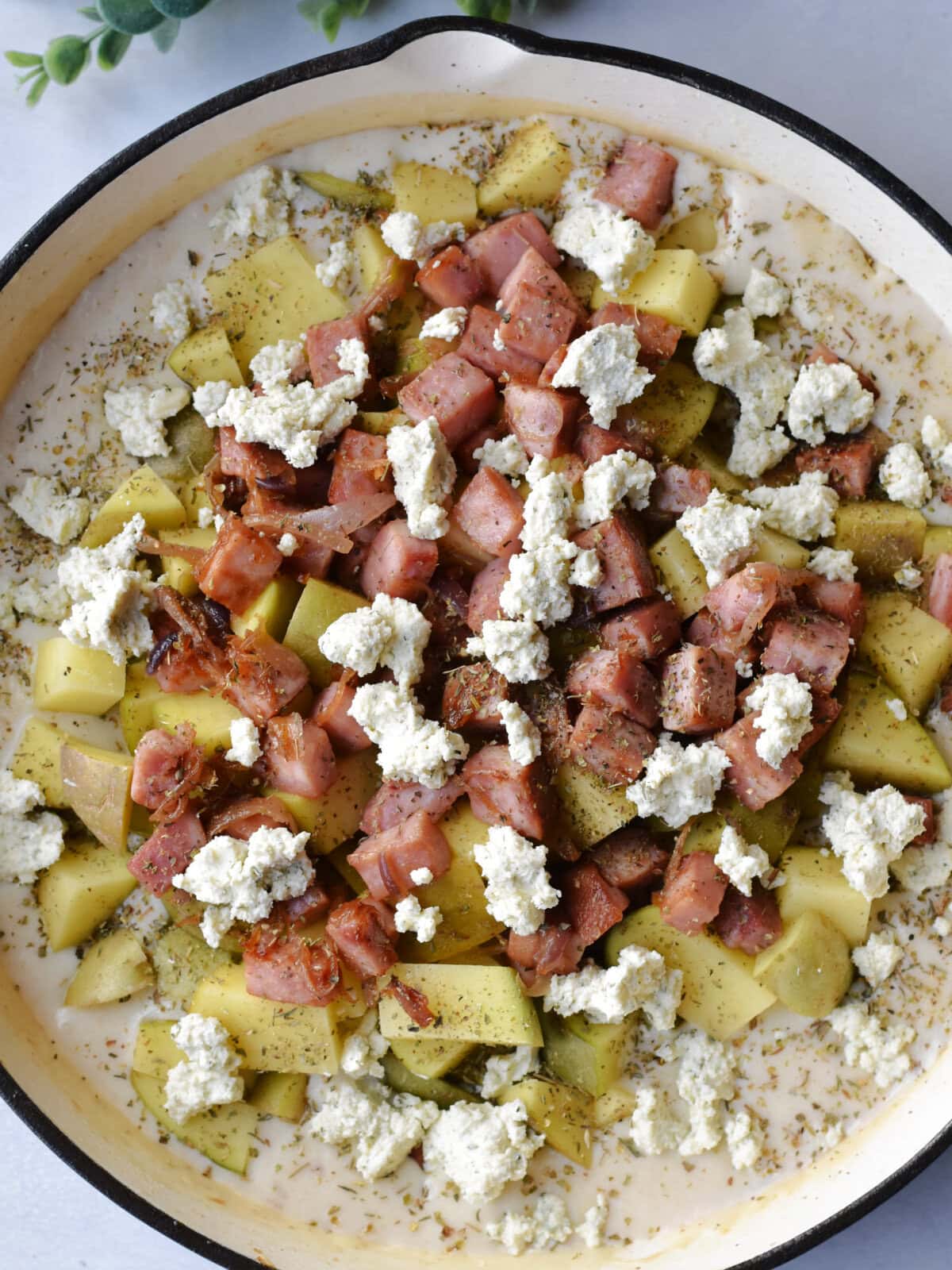 ham-steak-potatoes-uncooked The uncooked savory ham steak recipe in a skillet ready to go in the oven.