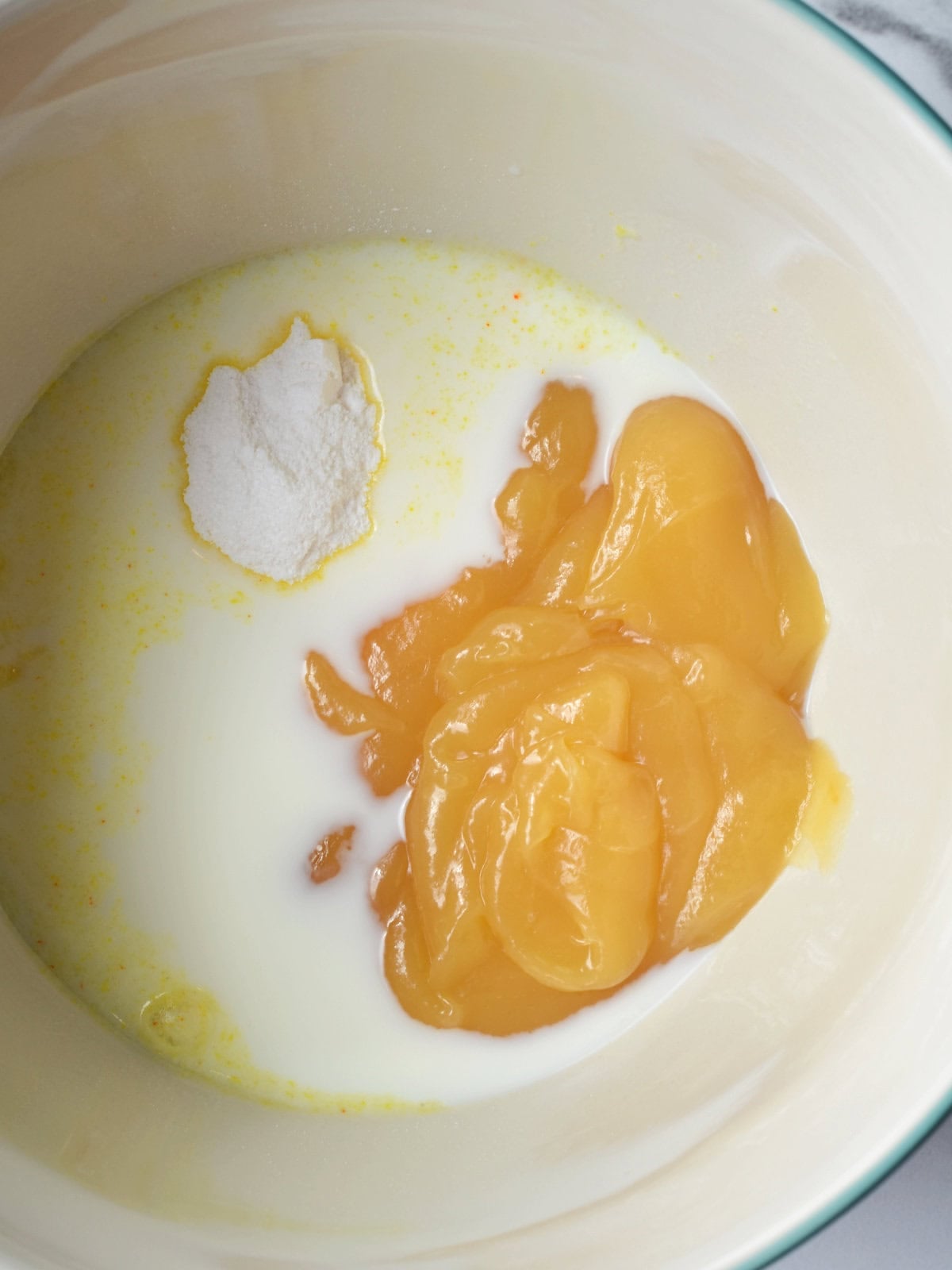 Pudding ingredients in a white mixing bowl. 