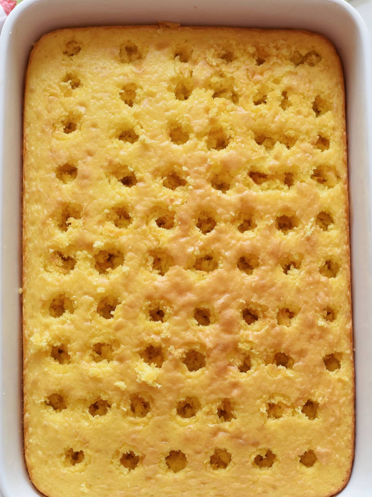 Cake with holes poked into it with a wooden spoon handle. 