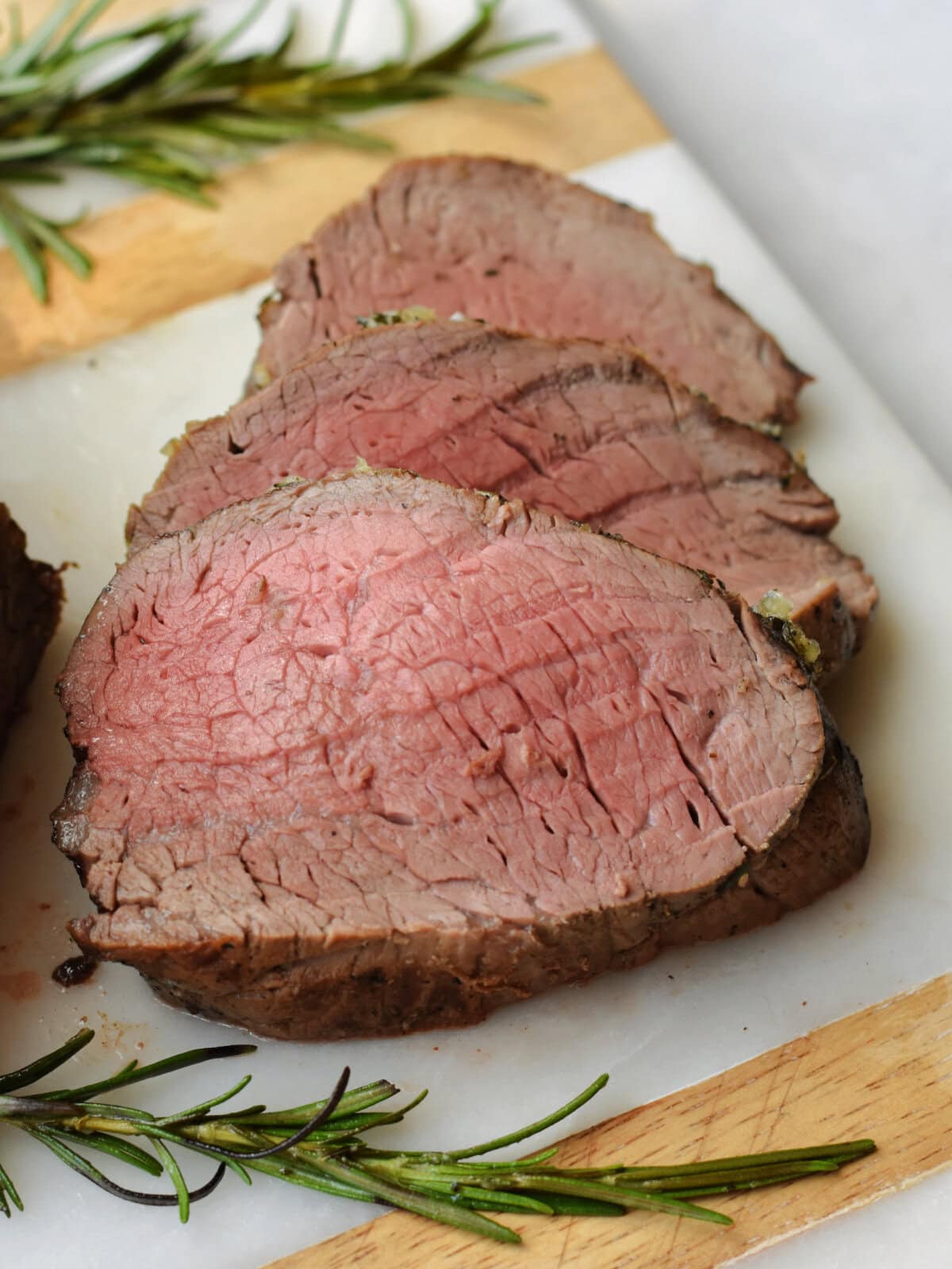 roasted-beef-tenderloin-rosemary Beef tenderloin slices with rosemary.