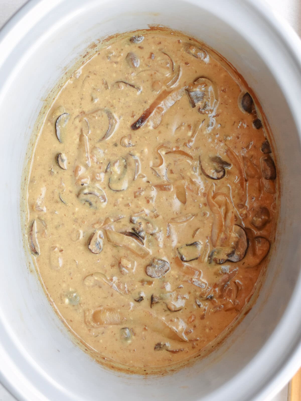 crockpot-round-steak-stirred Stirred mushroom gravy and beef in a slow cooker.