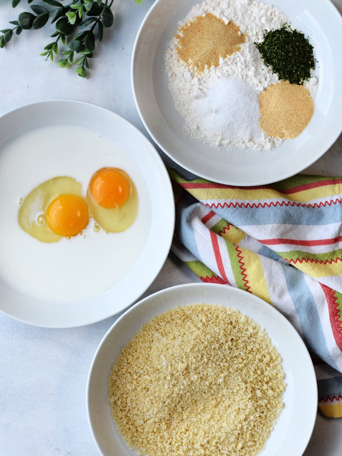 Breading stations prepared in white bowls. 