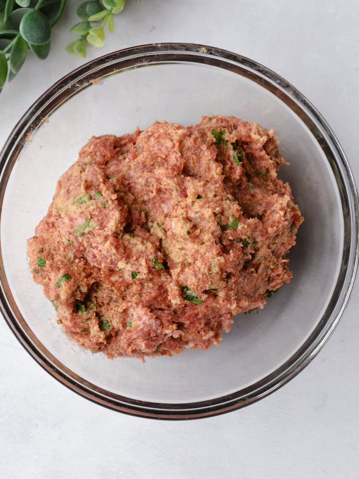 Seasoned ground pork in a mixing bowl. 