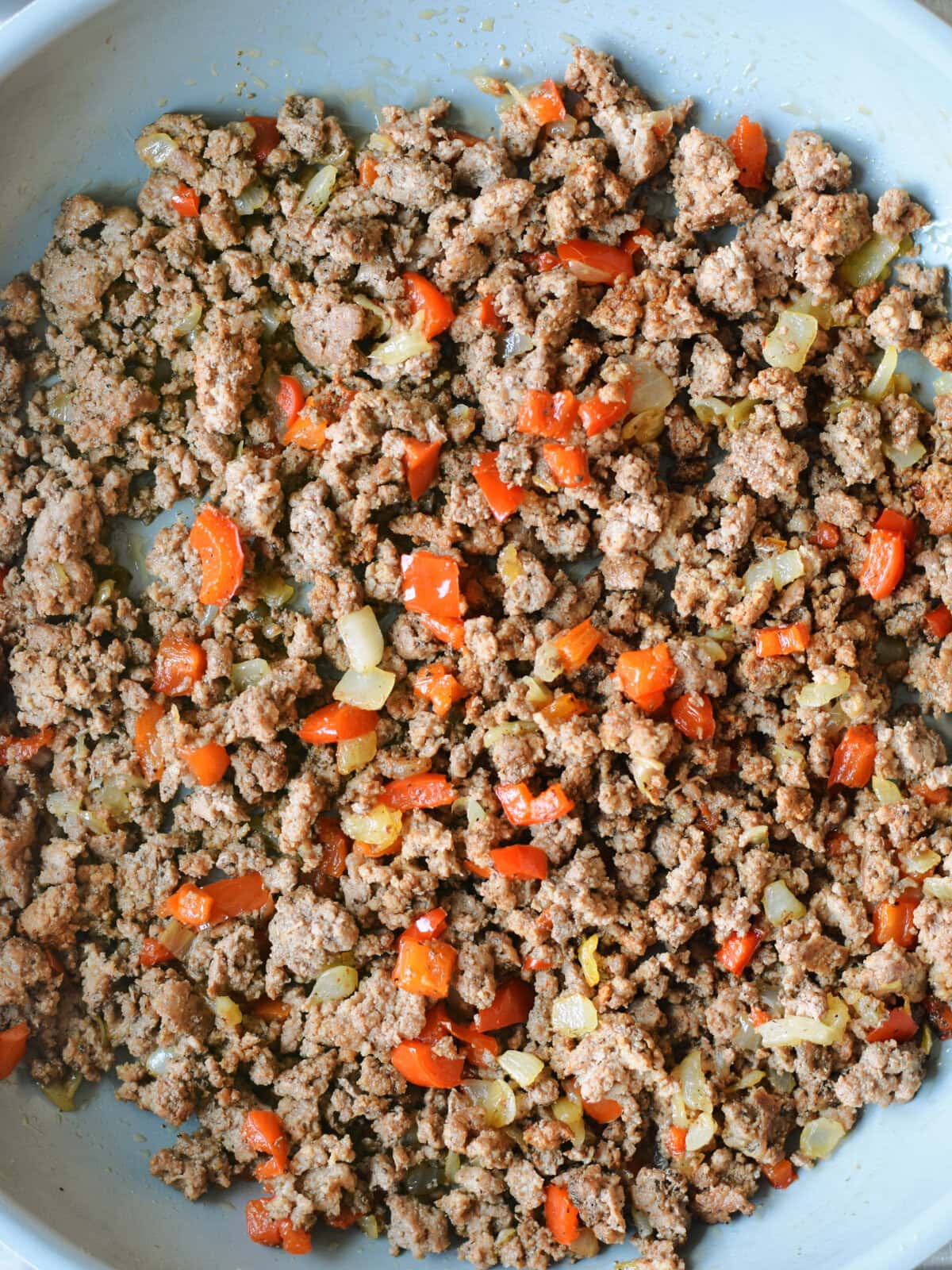 Ground beef and seasonings frying on the oven in the  skillet. 