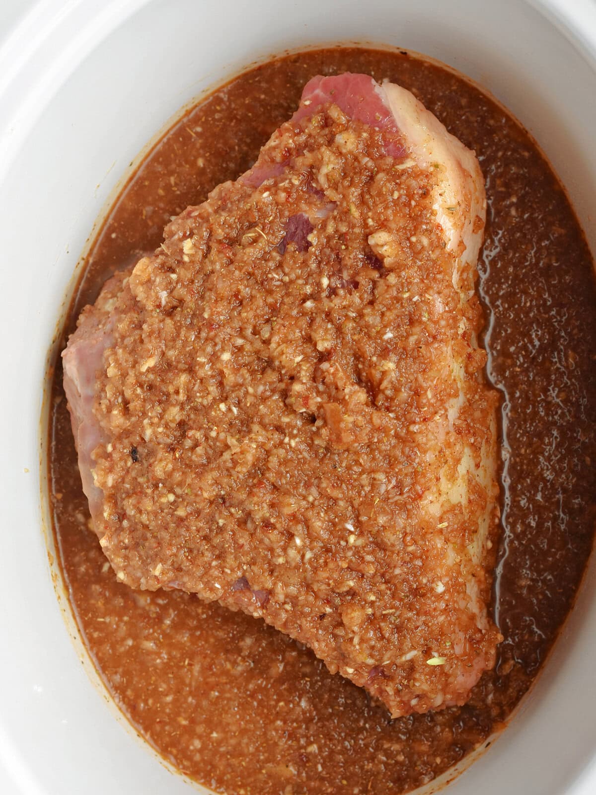 Marinade and beef in a slow cooker, ready to cook. 