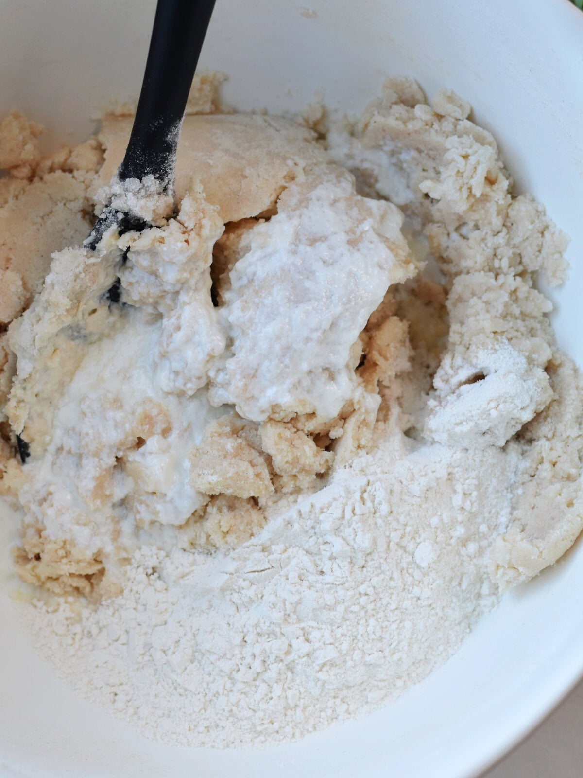 Flour and batter in a white mixing bowl. 