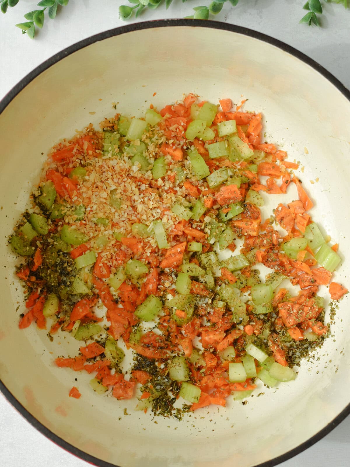 Carrots, celery, dehydrated onions and italian seasoning in a pan. 