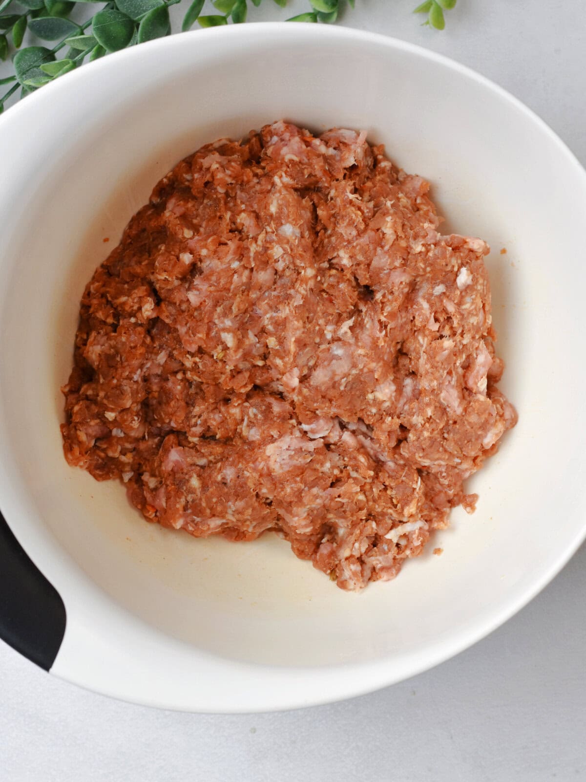 Combined meats in a mixing bowl. 
