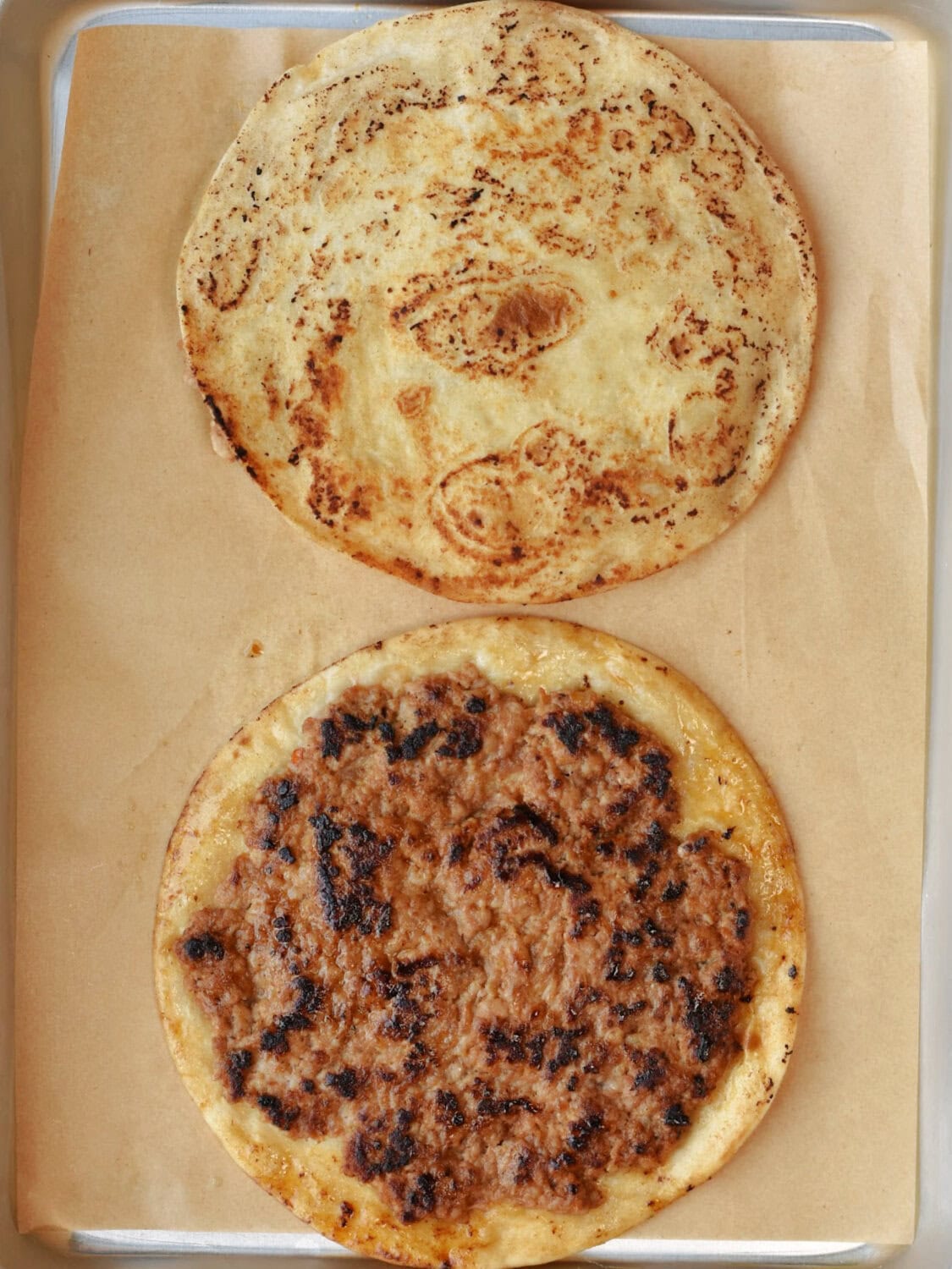 Smash Burger Tacos flipped to brown on the other side on a baking sheet. 